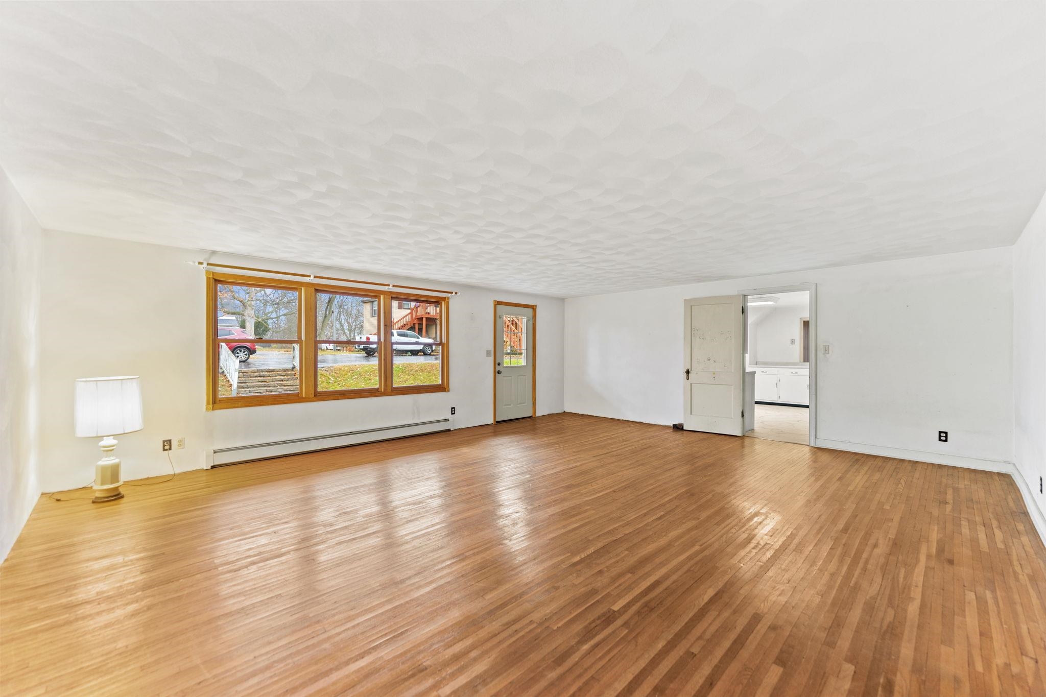 739 Elgin Street Cherry Valley, IL 61016 - Photo 4 of 41 a view of an empty room with wooden floor and a window