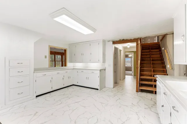 a view of a kitchen with white cabinets
