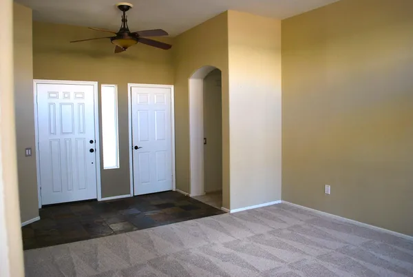 an empty room with a ceiling fan and a window