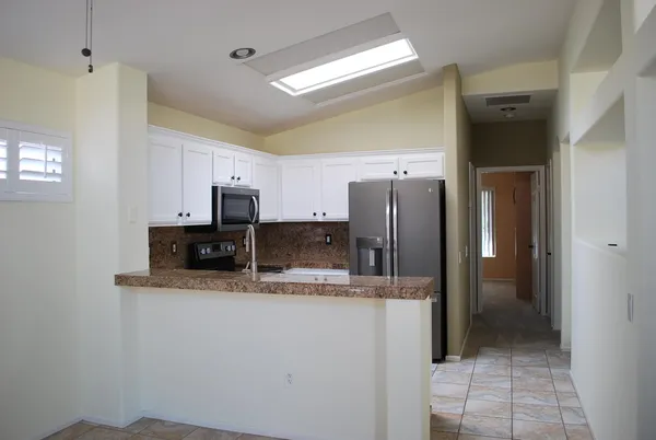 a kitchen with stainless steel appliances granite countertop a refrigerator and a sink