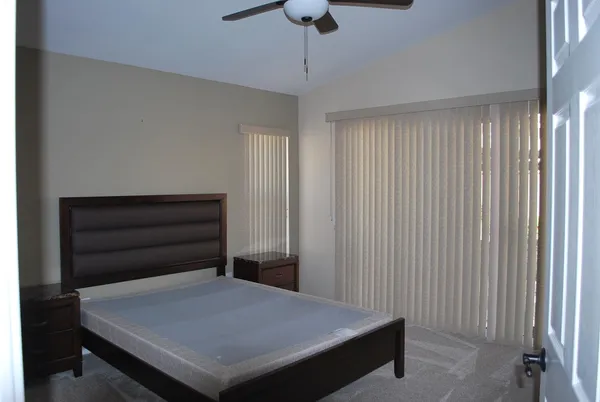 a room with a bed and a chandelier fan