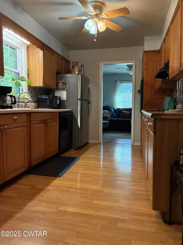 a kitchen with stainless steel appliances granite countertop a refrigerator a stove and a sink