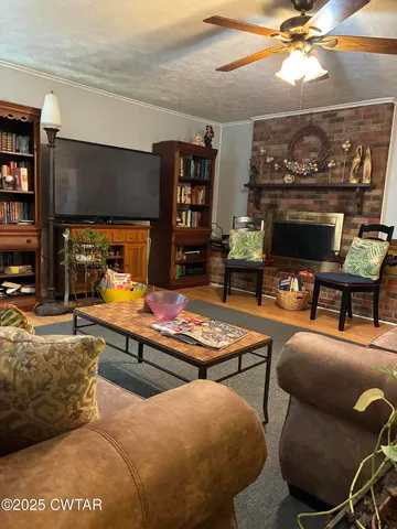 a living room with furniture a flat screen tv and a fireplace