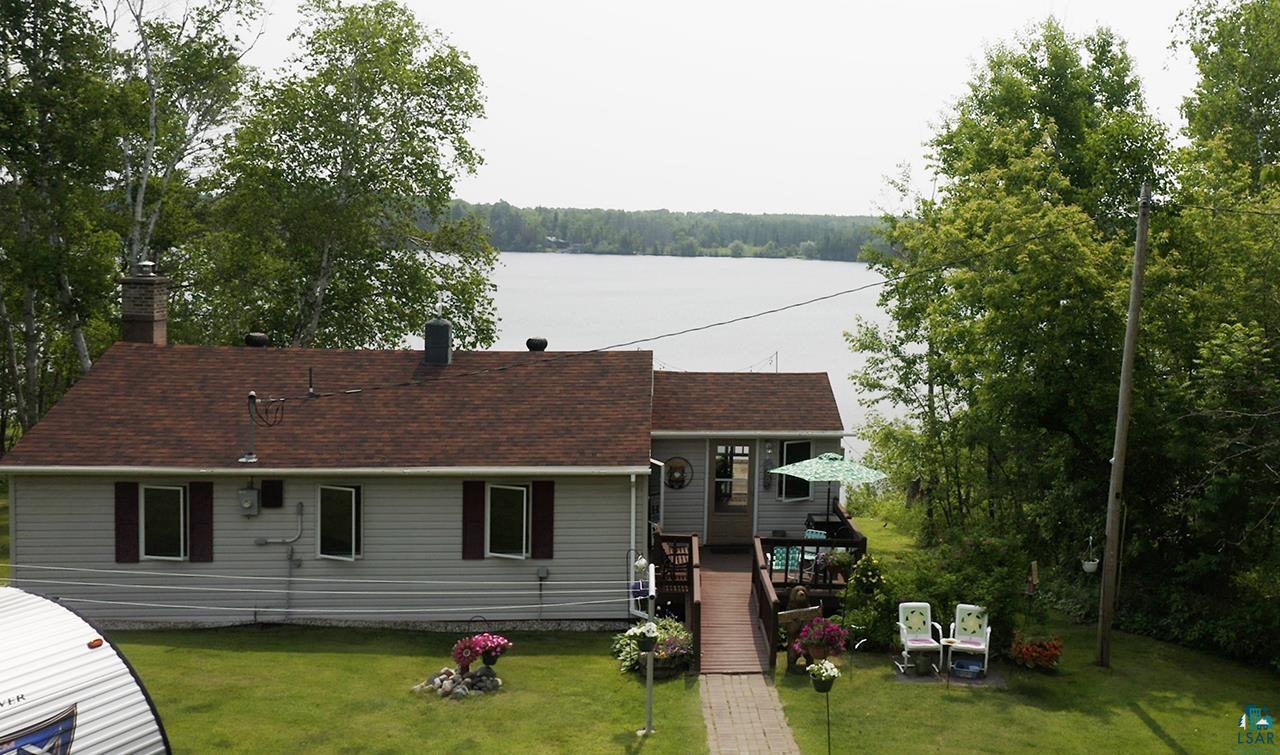 1198 West Mink Road Cotton, MN 55724 - Photo 20 of 23 Rear view of house with a chimney, a yard, a shingled roof, and a deck with water view
