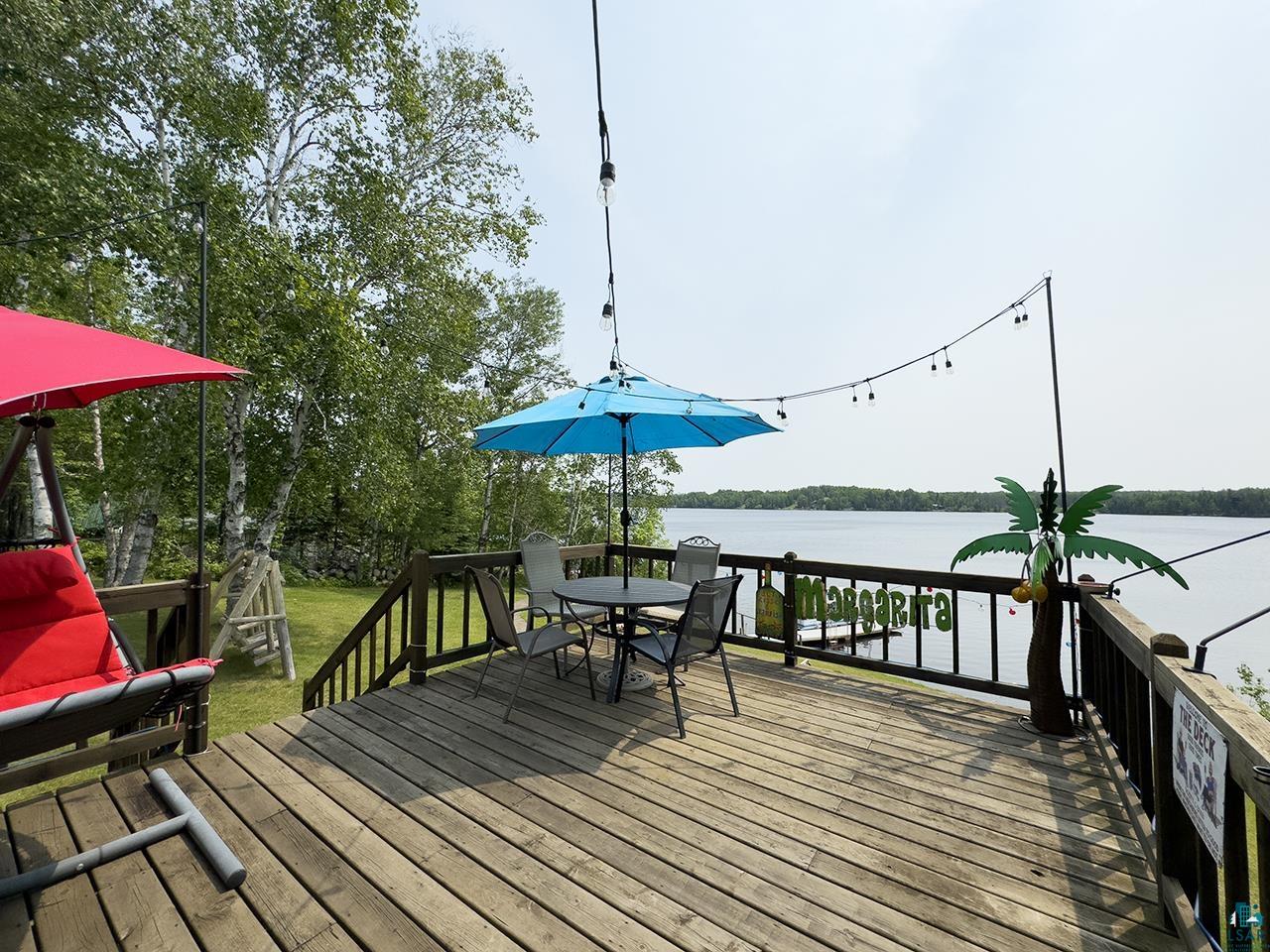 1198 West Mink Road Cotton, MN 55724 - Photo 2 of 23 Deck featuring a water view, outdoor dining area, and a yard