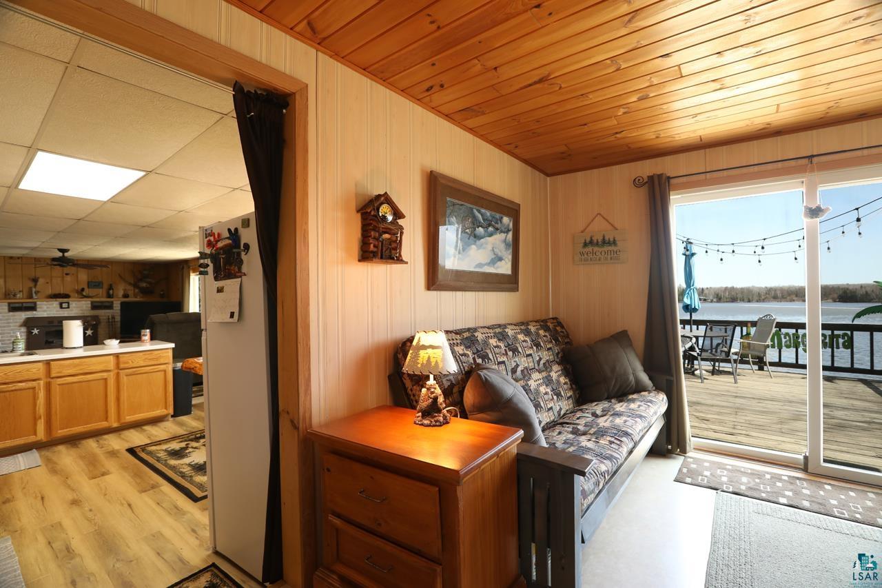 1198 West Mink Road Cotton, MN 55724 - Photo 3 of 23 Living area with a water view, wood walls, and wood ceiling