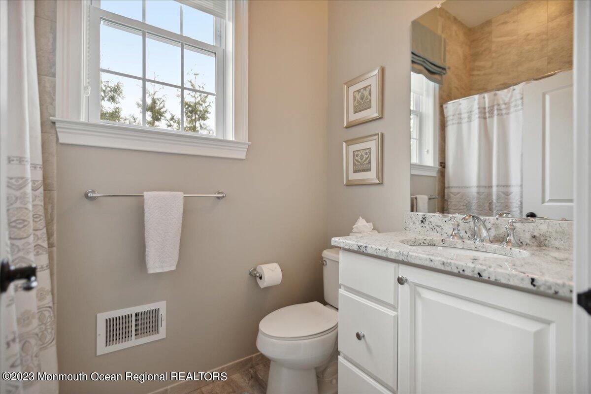 25 Windermere Road Lincroft, NJ 07738 - Photo 29 of 70 a bathroom with a granite countertop toilet a sink and a mirror