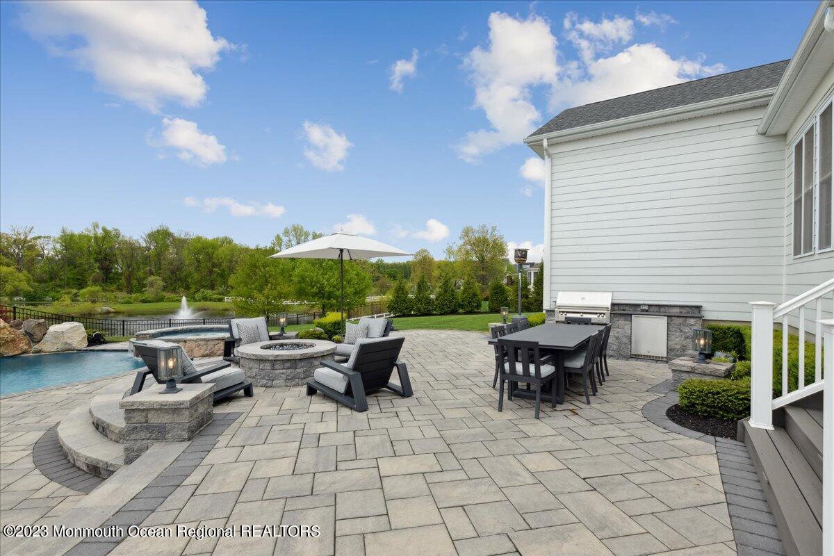 25 Windermere Road Lincroft, NJ 07738 - Photo 54 of 70 a view of a patio with couches and table and chairs with plants and lake view