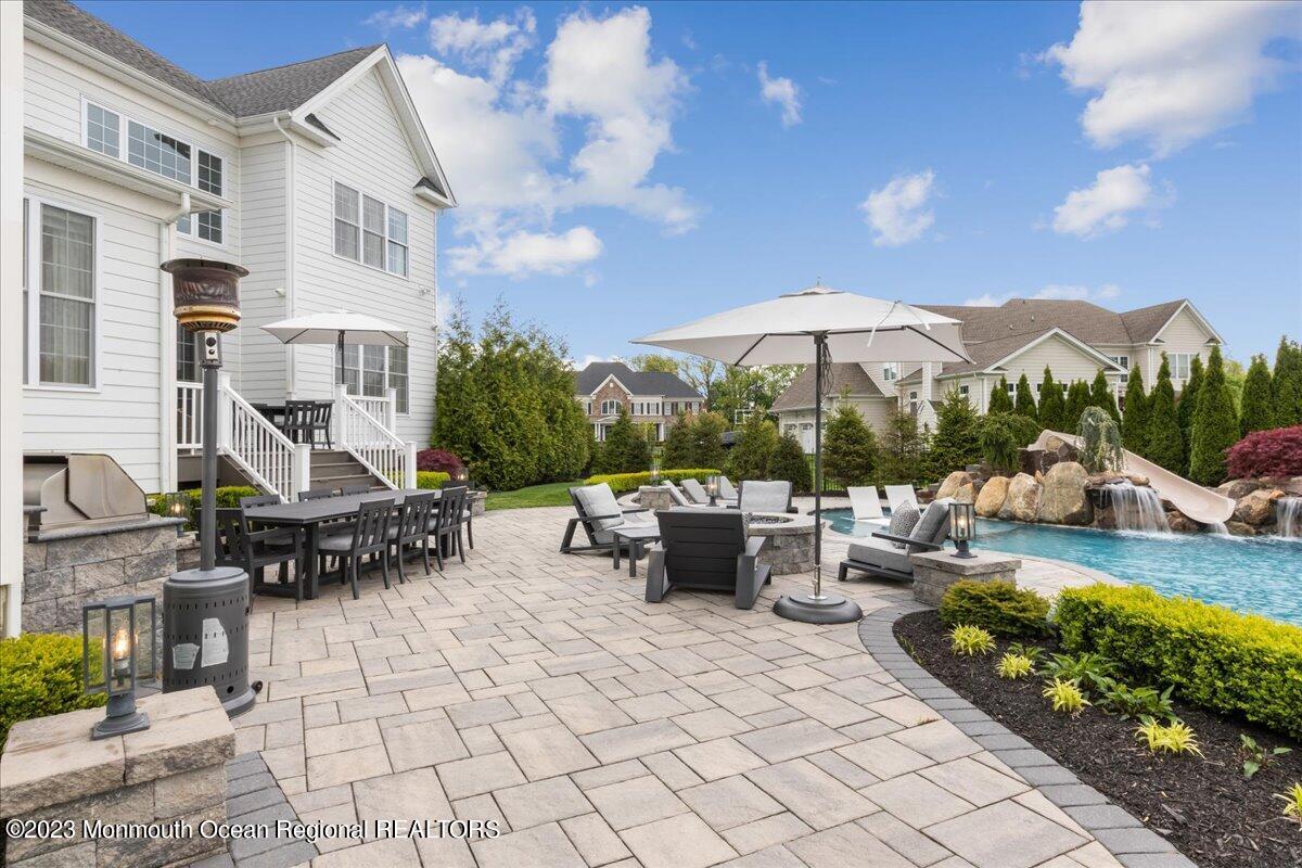 25 Windermere Road Lincroft, NJ 07738 - Photo 55 of 70 a view of a patio with couches table and chairs under an umbrella
