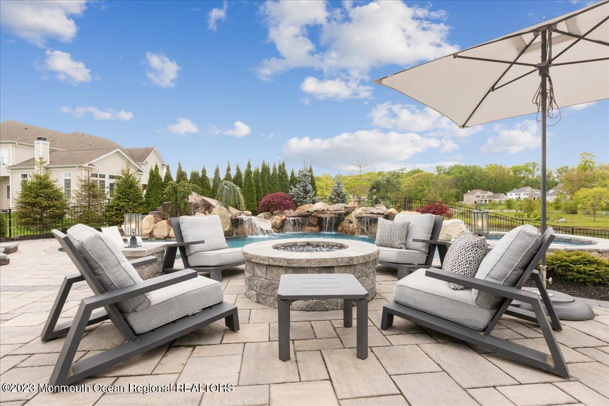25 Windermere Road Lincroft, NJ 07738 - Photo 56 of 70 a view of a terrace with furniture and a fire pit
