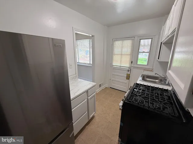 a kitchen with granite countertop a stove and a refrigerator