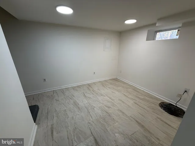 an empty room with wooden floor and sink