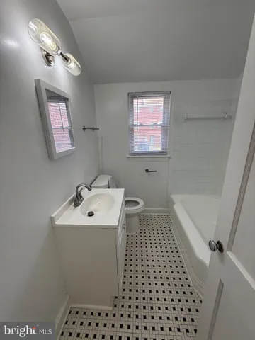 a bathroom with a sink a toilet a mirror and shower
