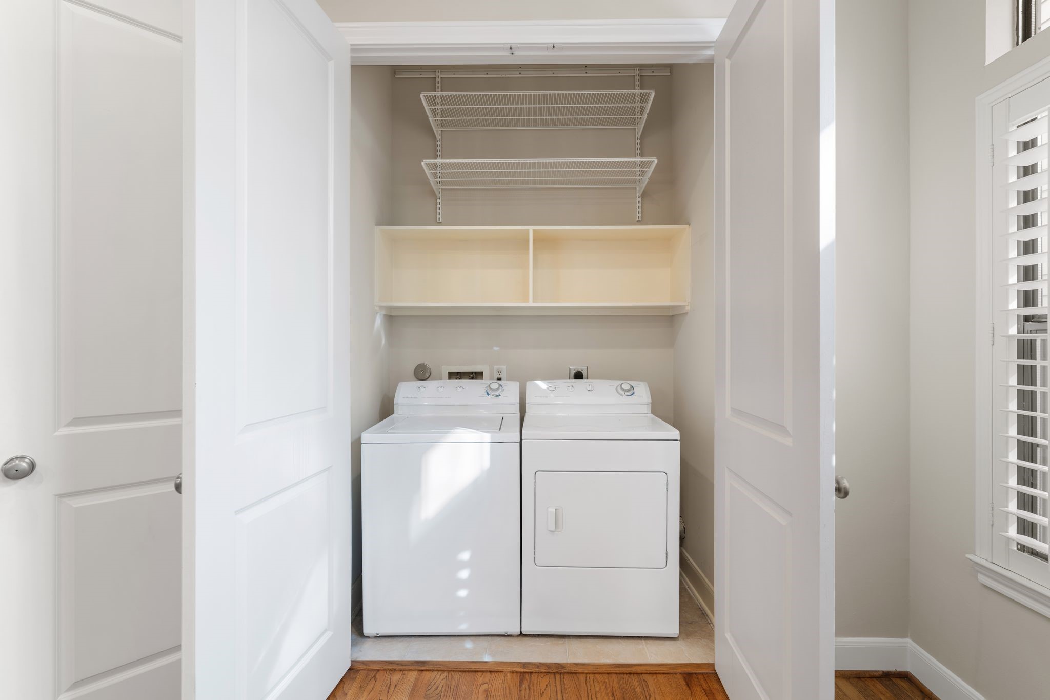 121 Roy Street Houston, TX 77007 - Photo 13 of 29 Laundry with full size washer and dryer, open shelving above for storage, and double doors.