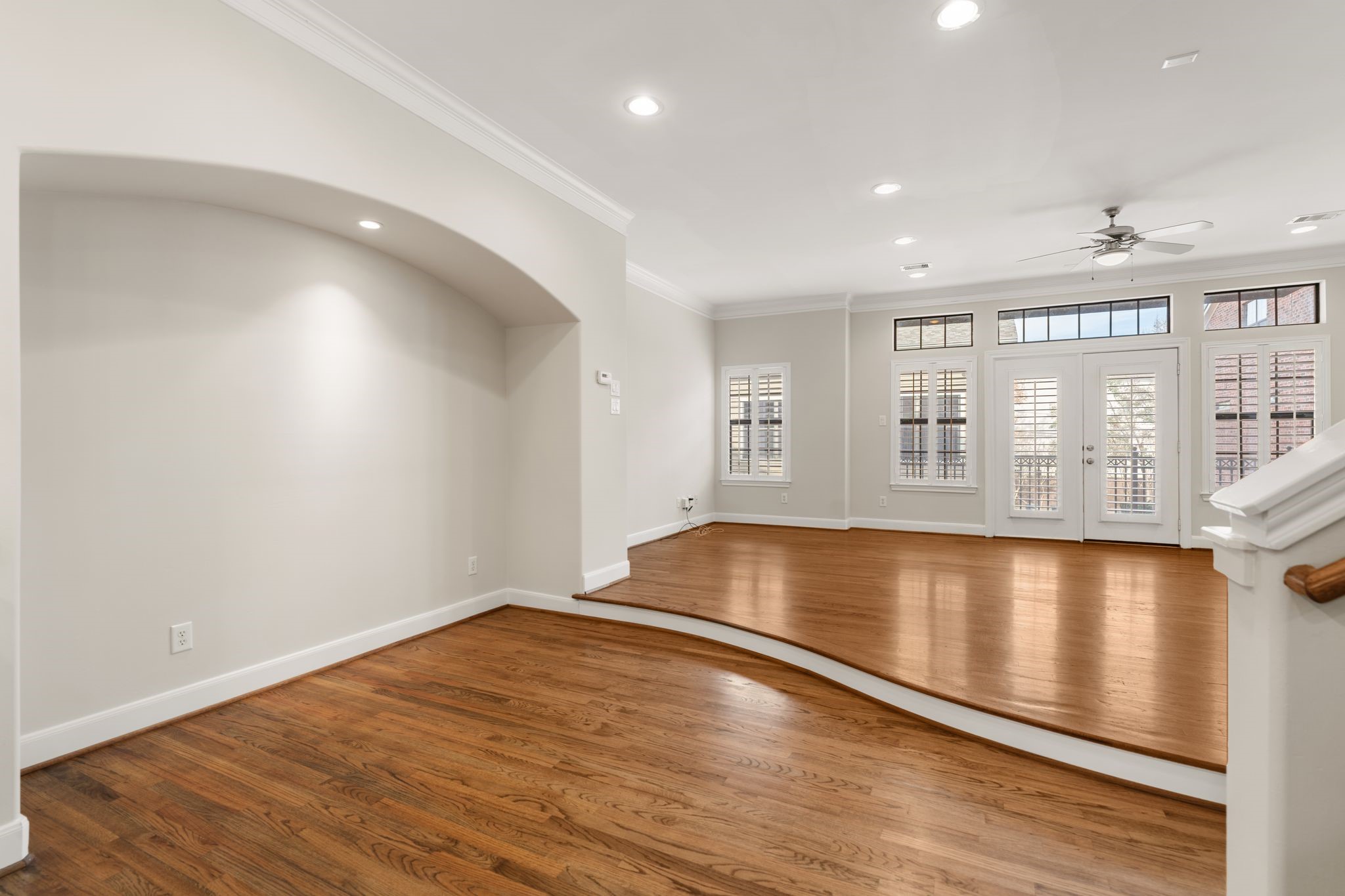 121 Roy Street Houston, TX 77007 - Photo 8 of 29 This spacious living area features elegant hardwood floors, high ceilings, and abundant natural light through large windows with shutters. A ceiling fan and recessed lighting add comfort and style, while the open layout offers versatile design options.