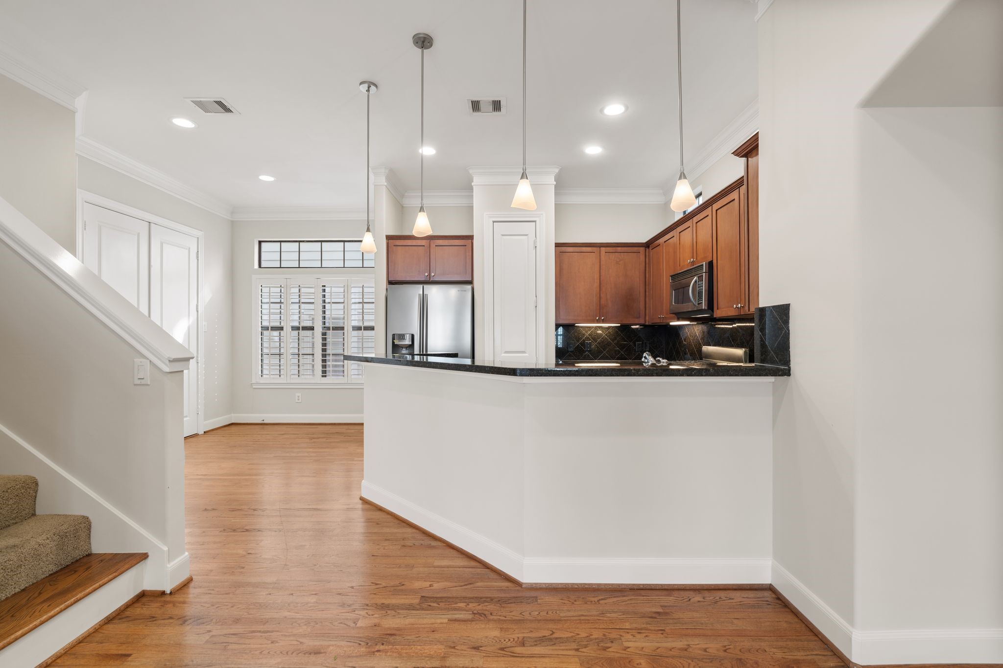 121 Roy Street Houston, TX 77007 - Photo 9 of 29 The kitchen has hardwood floors, stainless steel appliances, and wood cabinets. It is well-lit with recessed and pendant lighting featuring a breakfast bar that opens into the living area.
