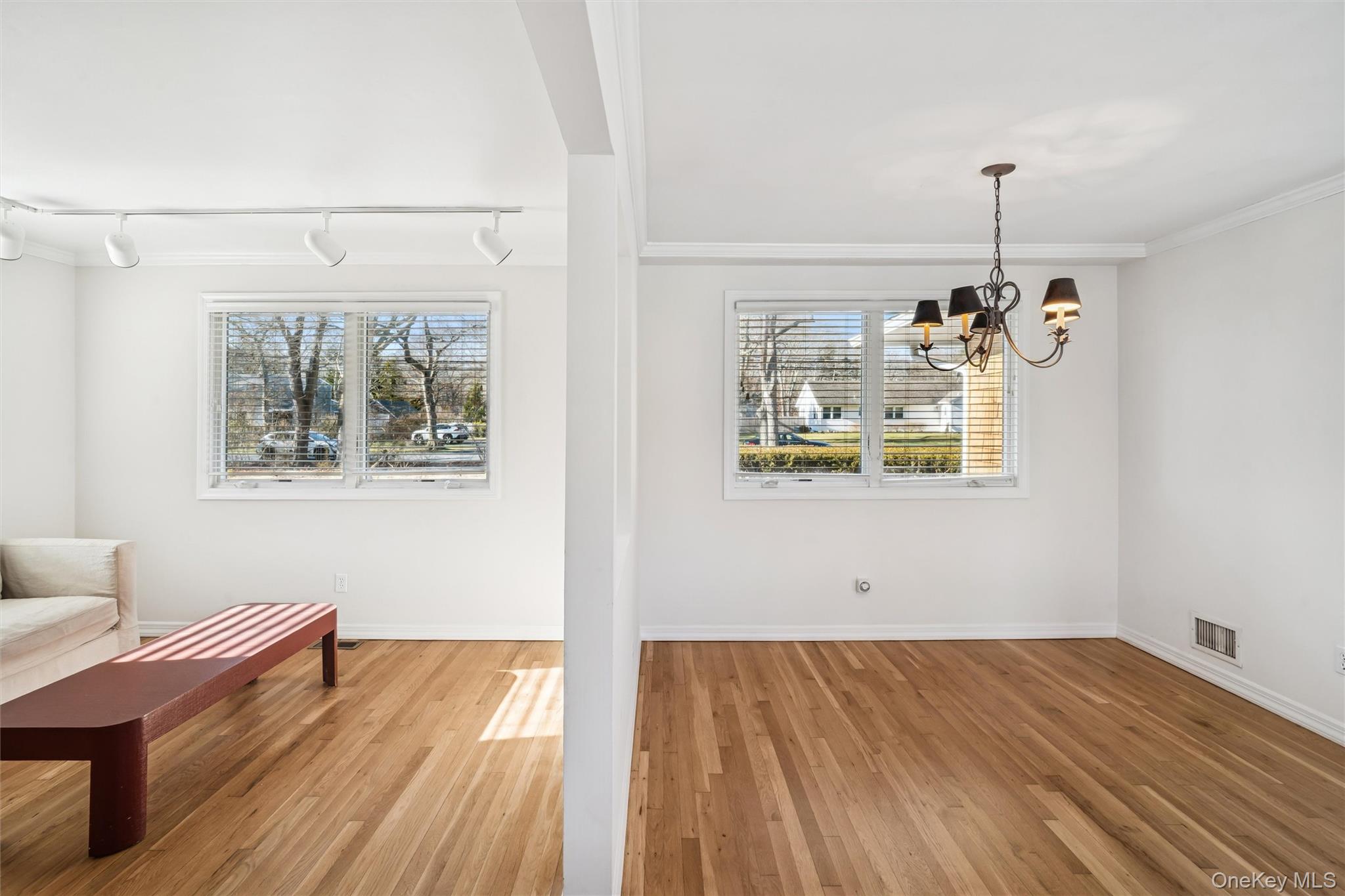 58 Old Depot Road Quogue, NY 11959 - Photo 7 of 28 a dining room with wooden floor a chandelier a wooden floor and a window