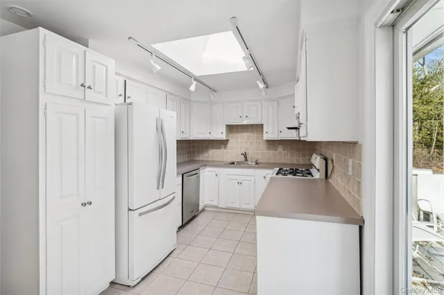 a kitchen with white cabinets and white appliances