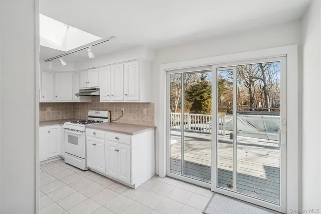 a kitchen with stainless steel appliances granite countertop a stove and white cabinets