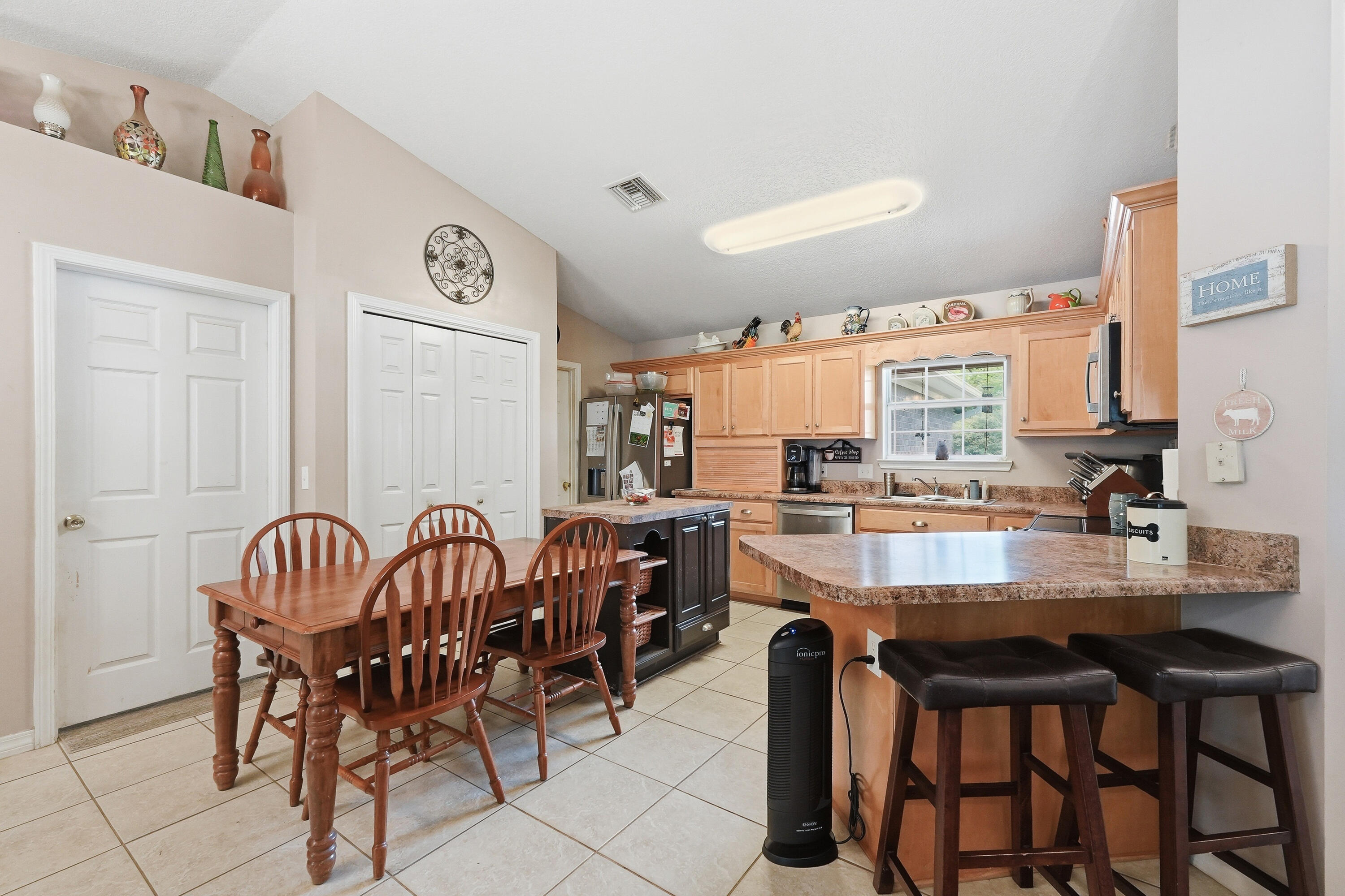 4237 Melton Road Milton, FL 32583 - Photo 12 of 43 a kitchen with stainless steel appliances granite countertop a sink a stove a dining table and chairs