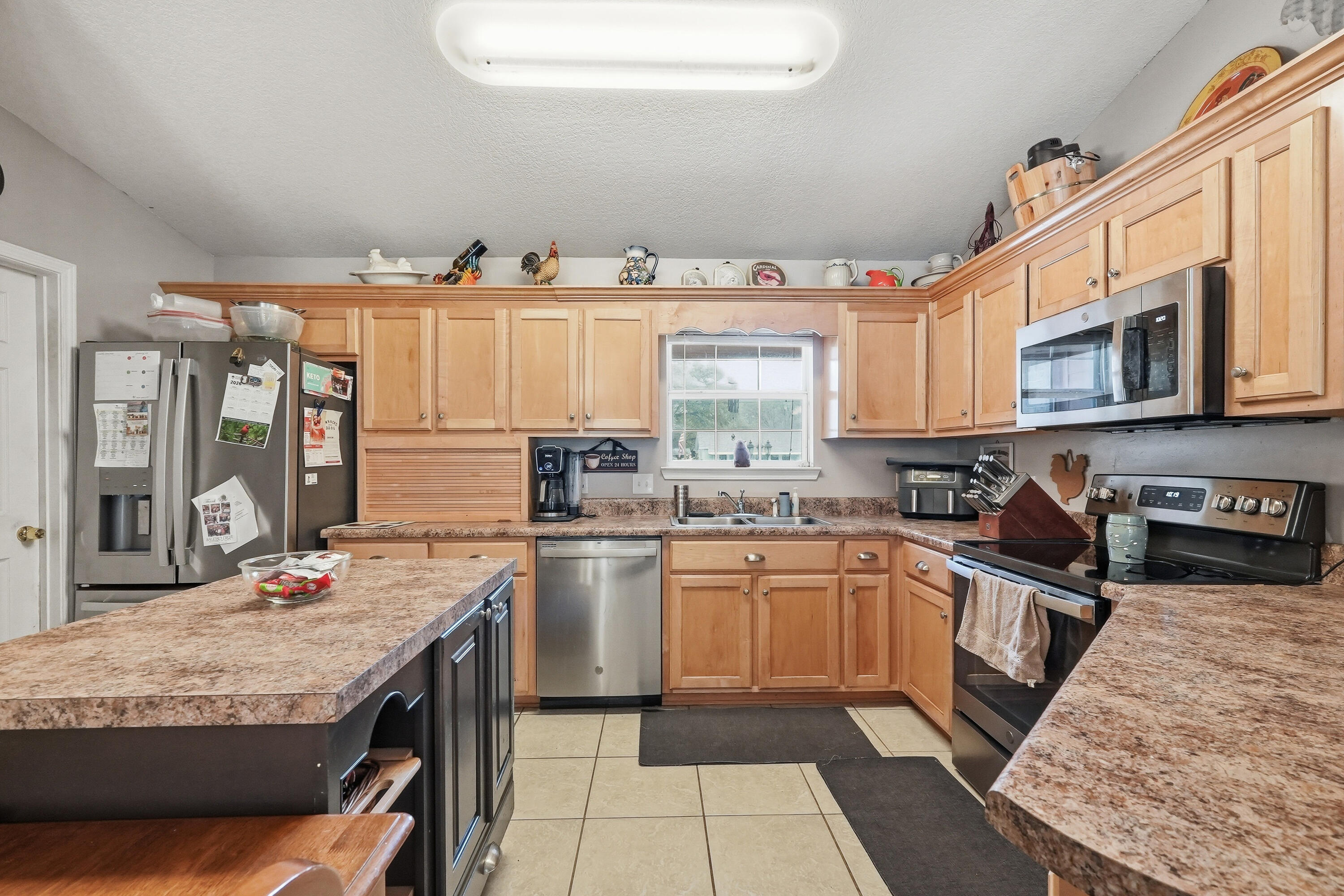 4237 Melton Road Milton, FL 32583 - Photo 13 of 43 a kitchen with stainless steel appliances granite countertop a sink stove and refrigerator