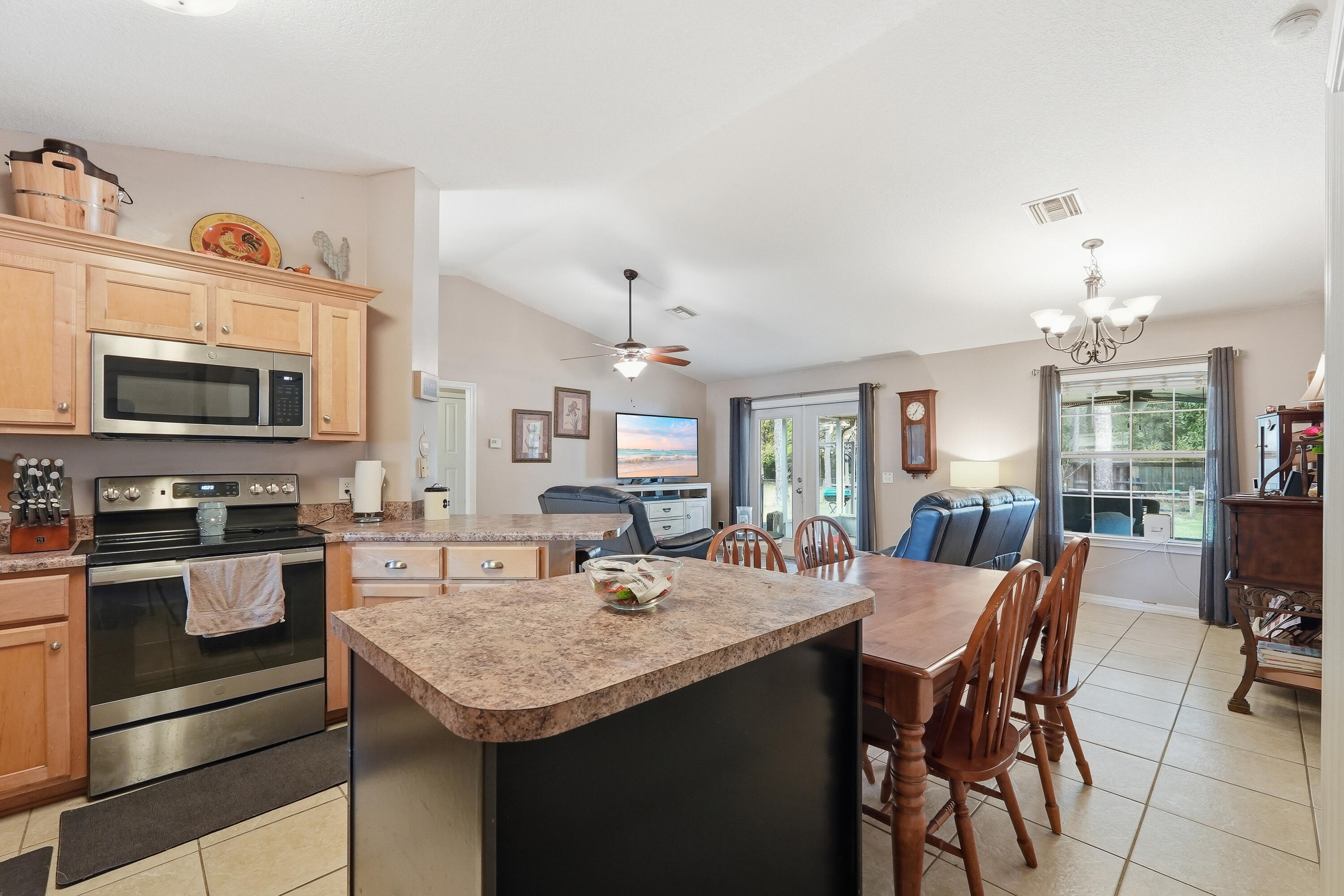 4237 Melton Road Milton, FL 32583 - Photo 17 of 43 a kitchen with a stove a microwave and dining table