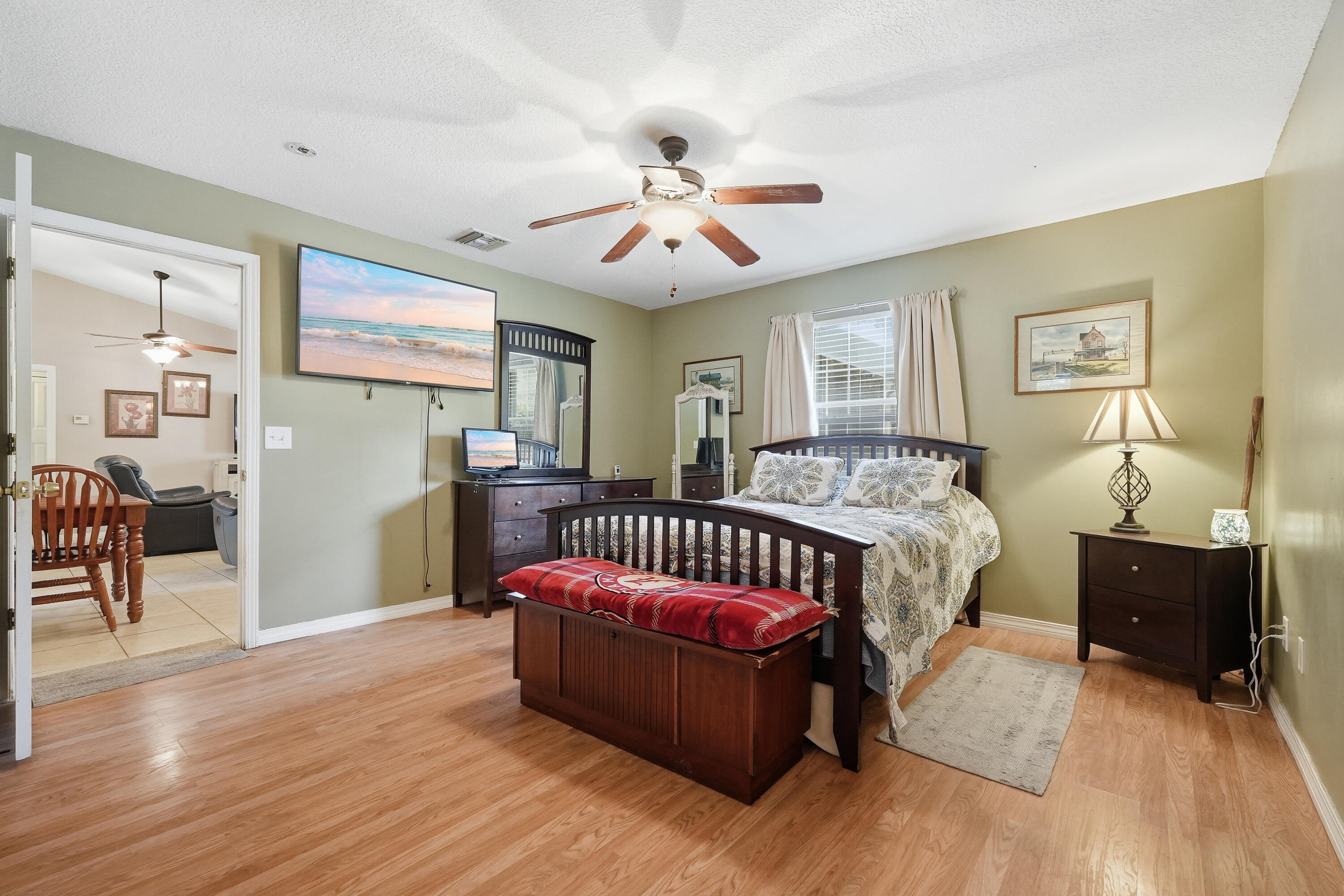 4237 Melton Road Milton, FL 32583 - Photo 19 of 43 a spacious bedroom with a bed and a chandelier