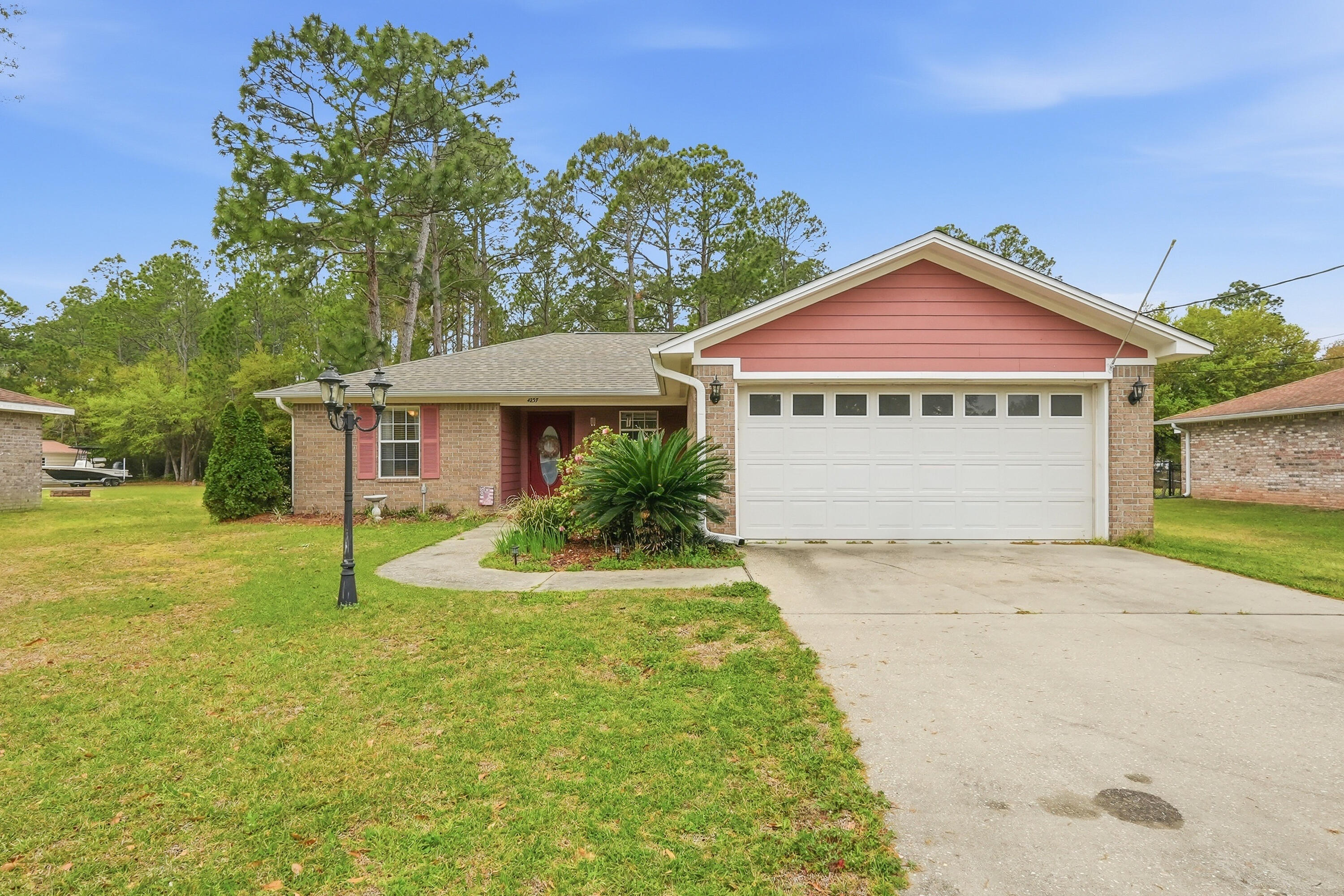 4237 Melton Road Milton, FL 32583 - Photo 2 of 43 a front view of a house with a yard and garage