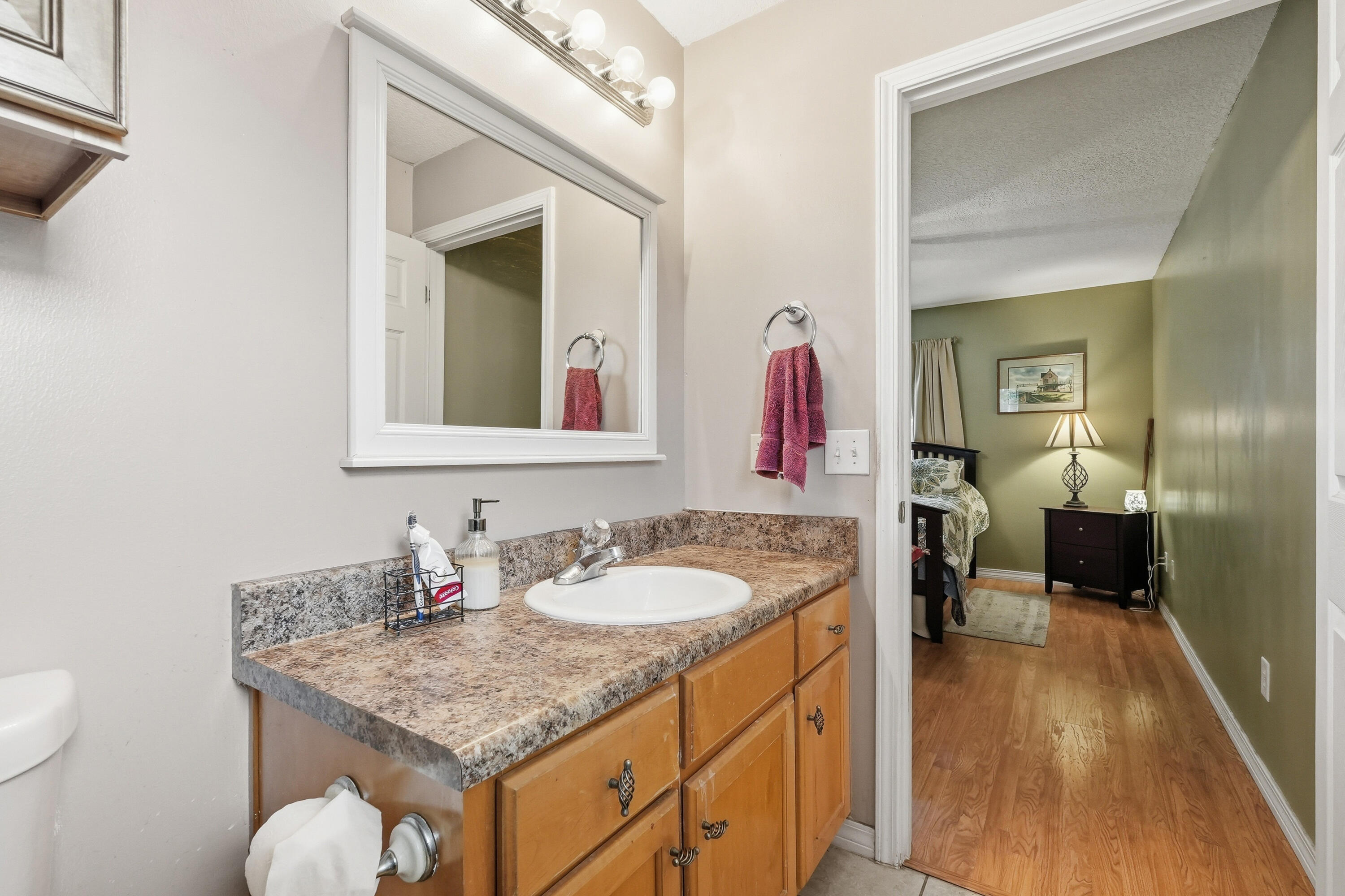 4237 Melton Road Milton, FL 32583 - Photo 21 of 43 a en suite bathroom with a granite countertop sink and a mirror