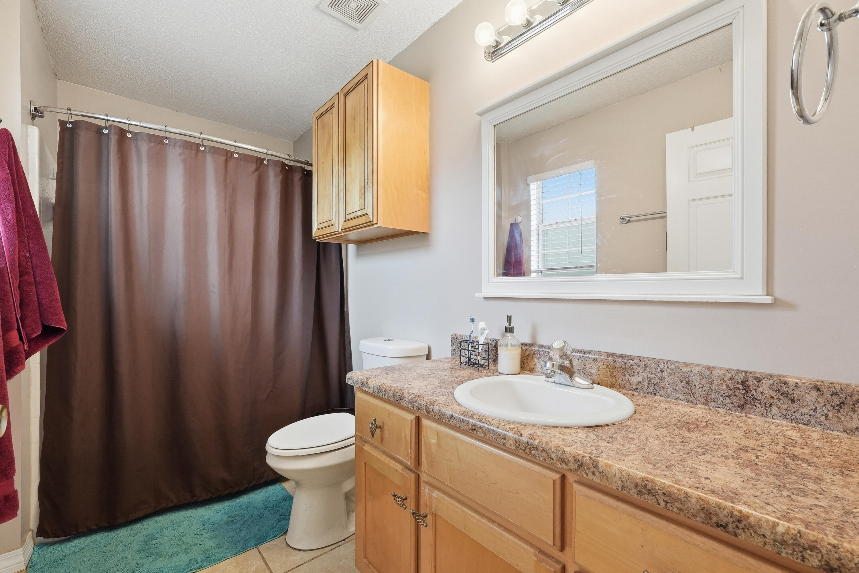 4237 Melton Road Milton, FL 32583 - Photo 22 of 43 a bathroom with a granite countertop sink toilet and mirror