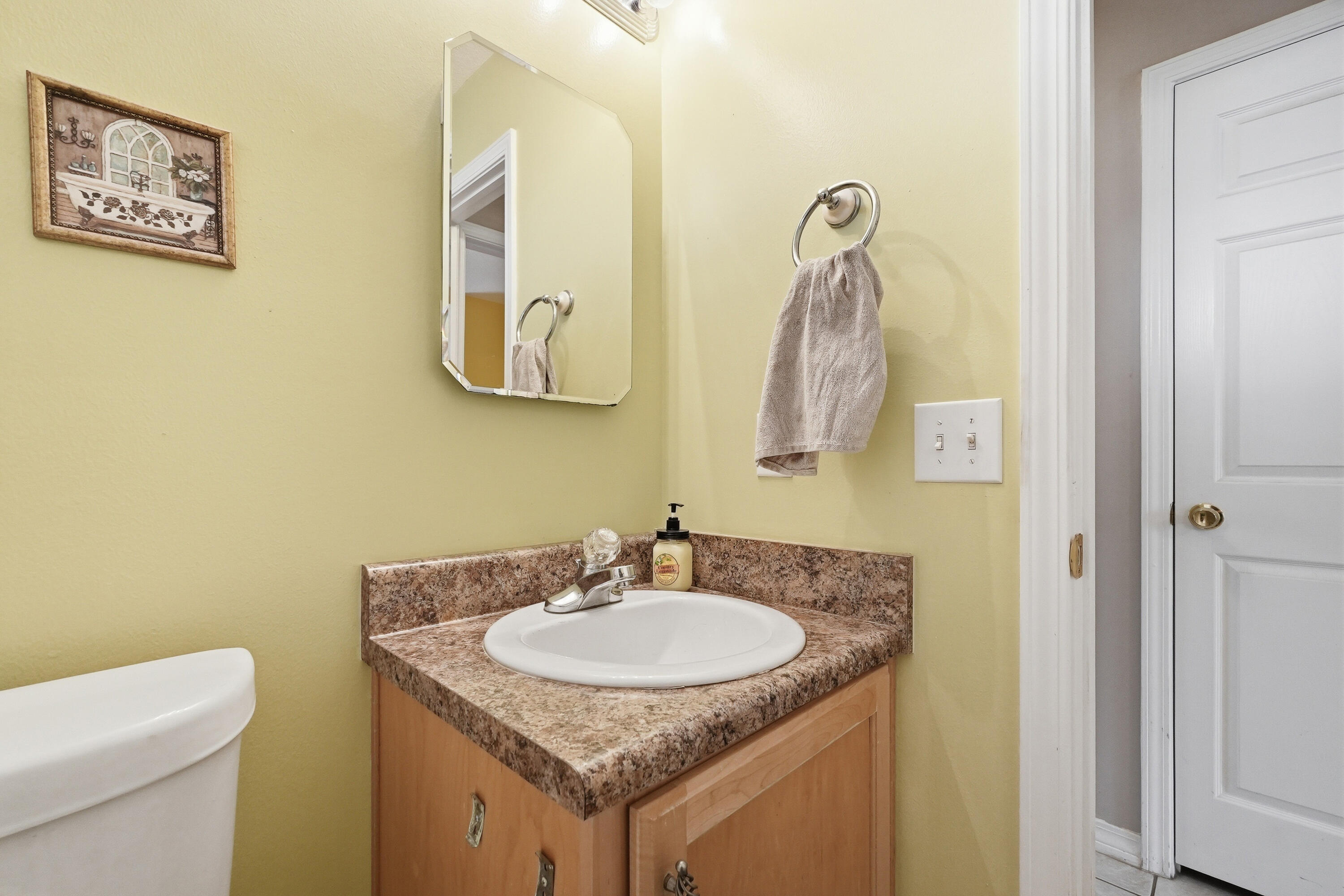 4237 Melton Road Milton, FL 32583 - Photo 28 of 43 a bathroom with a granite countertop sink a toilet and a mirror