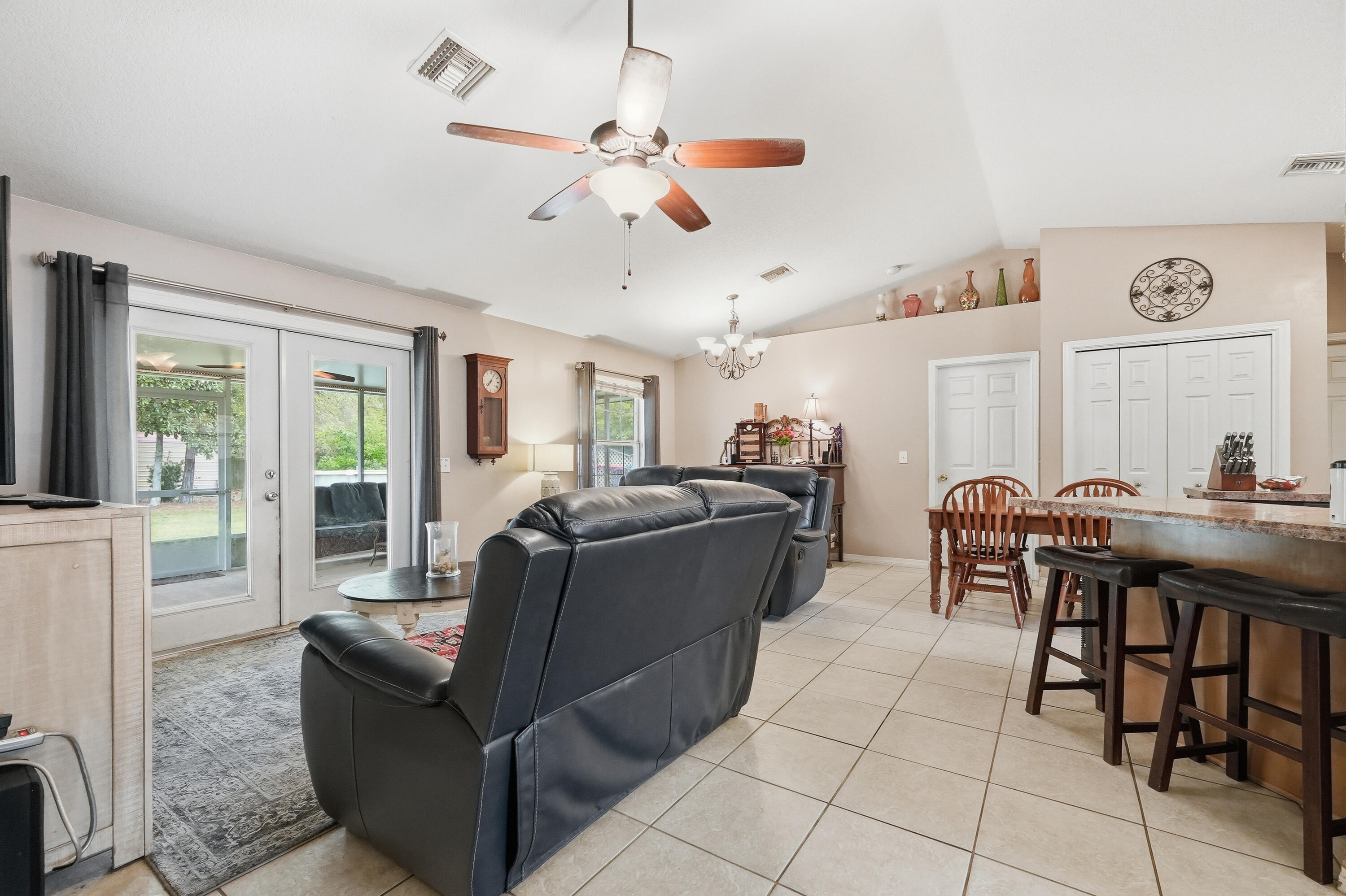 4237 Melton Road Milton, FL 32583 - Photo 8 of 43 a living room with furniture a dining table and a clock