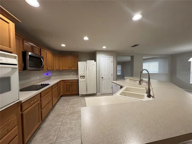 a kitchen with stainless steel appliances granite countertop a sink a stove and a refrigerator