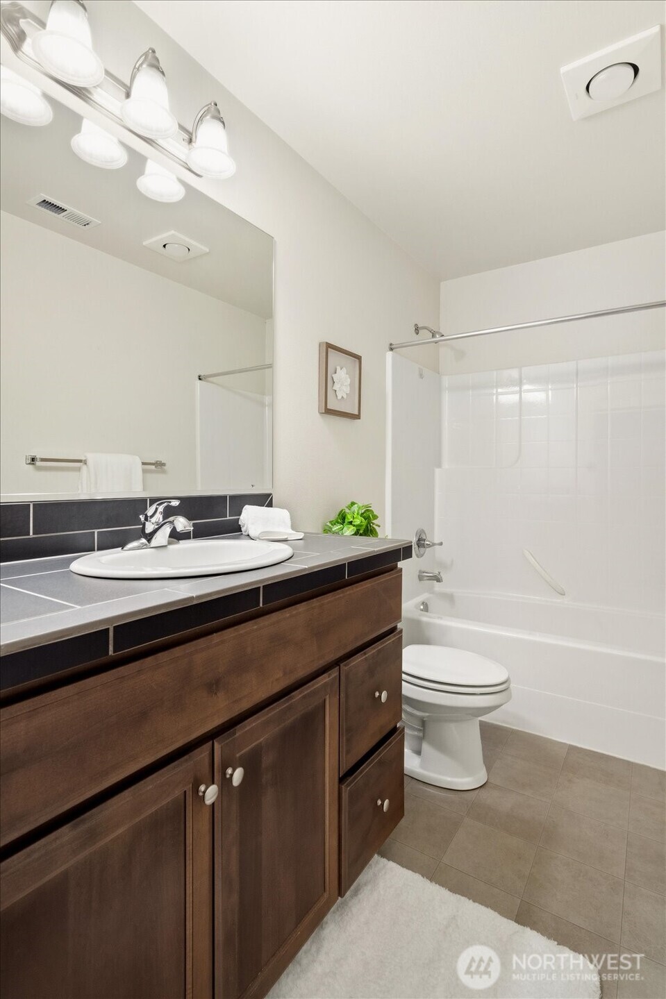 12102 Northeast 174th Street, Unit 1 Bothell, WA 98011 - Photo 32 of 40 a bathroom with a granite countertop sink a toilet and a bathtub