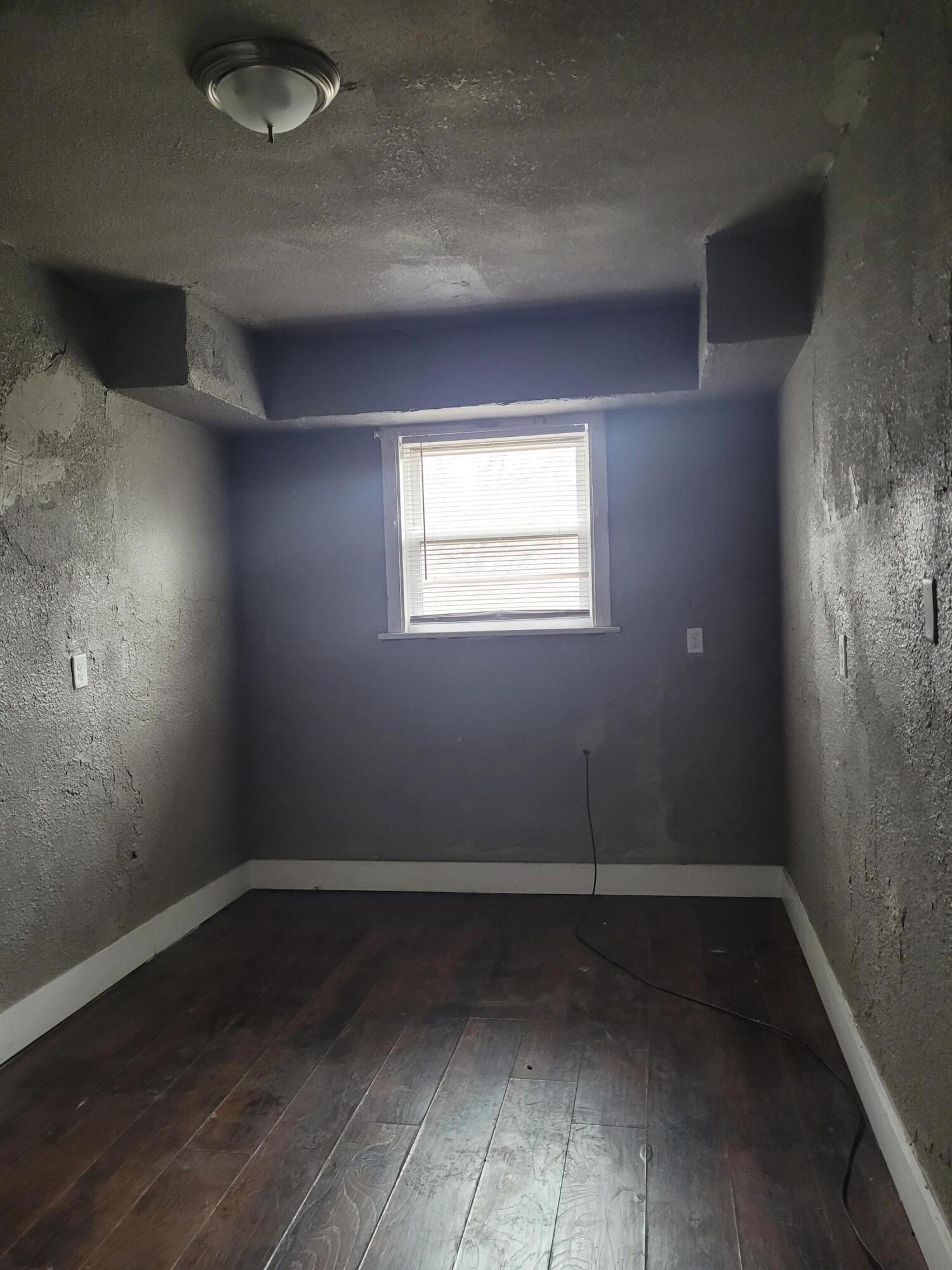 824 Tyler Street Gary, IN 46402 - Photo 5 of 14 an empty room with wooden floor and windows