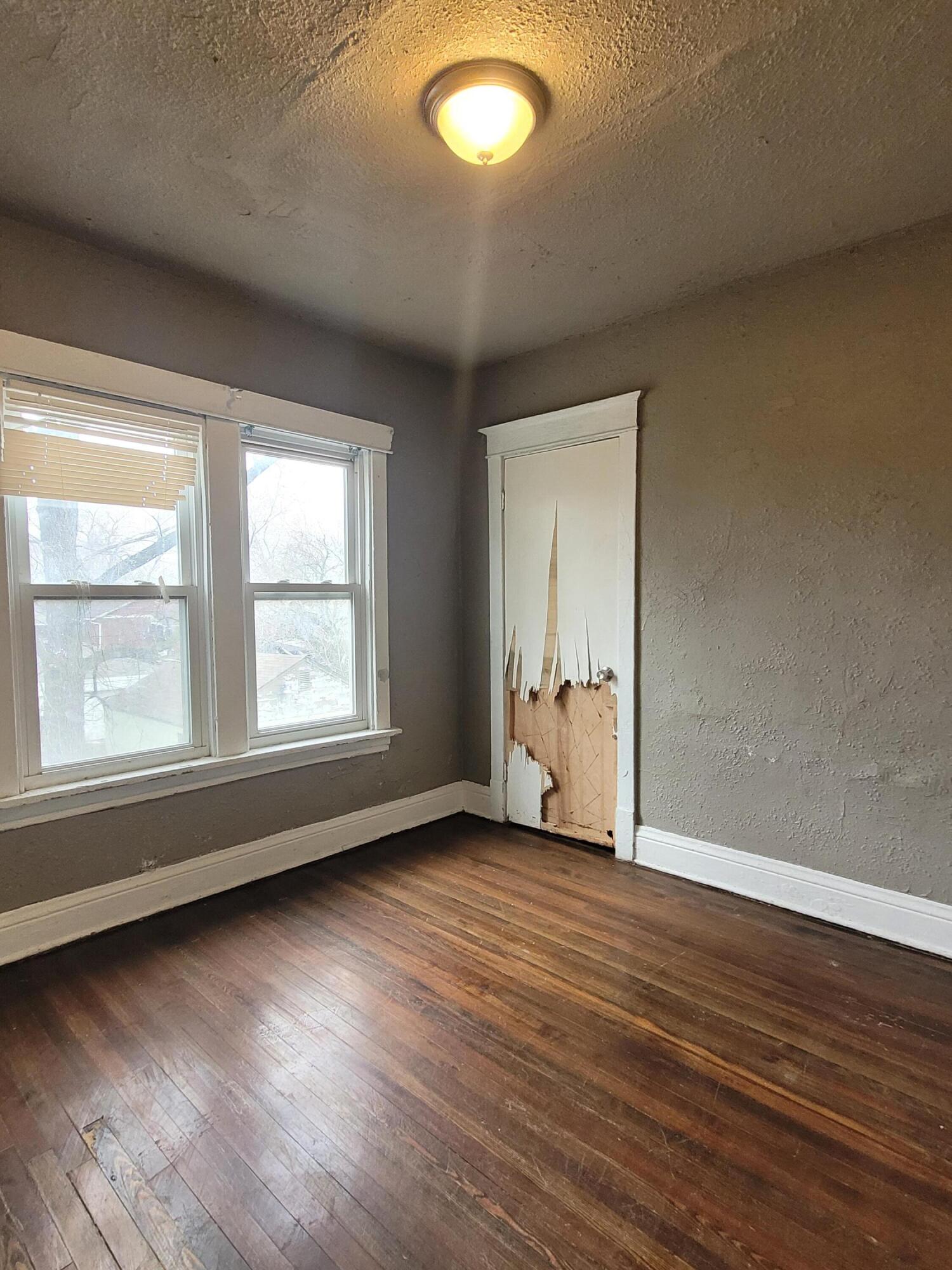 824 Tyler Street Gary, IN 46402 - Photo 9 of 14 an empty room with wooden floor and windows