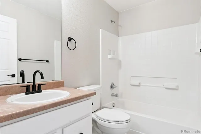 a bathroom with a sink a toilet and a shower