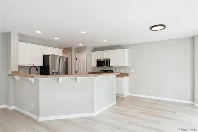 a kitchen with stainless steel appliances a refrigerator sink and microwave