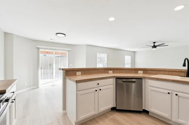 a kitchen with white cabinets and sink