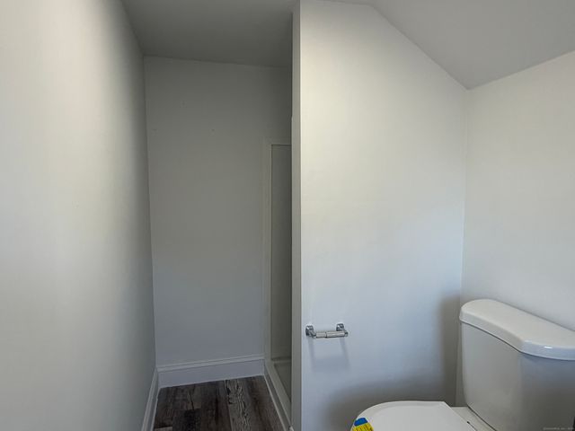 a white toilet sitting next to a white wall