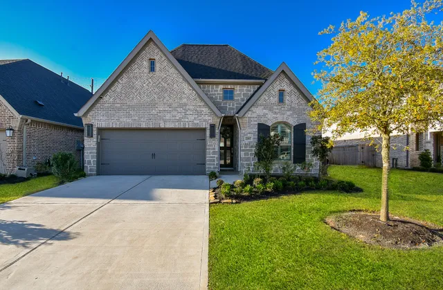 a front view of a house with a yard and garage