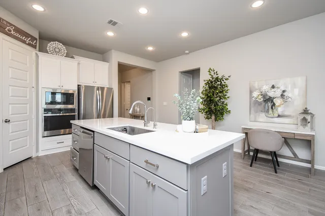 a bedroom with a bed and a baby crib with wooden floor