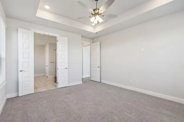 an empty room with a ceiling fan and a bathroom