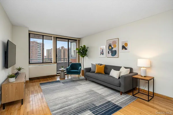 a living room with furniture and a flat screen tv with wooden floor