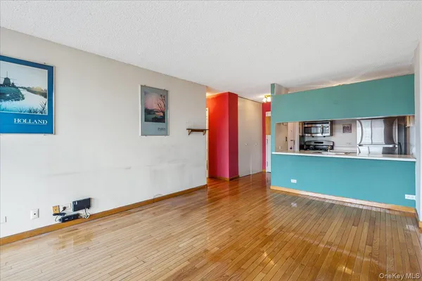 a view of a room with wooden floor and a ceiling fan