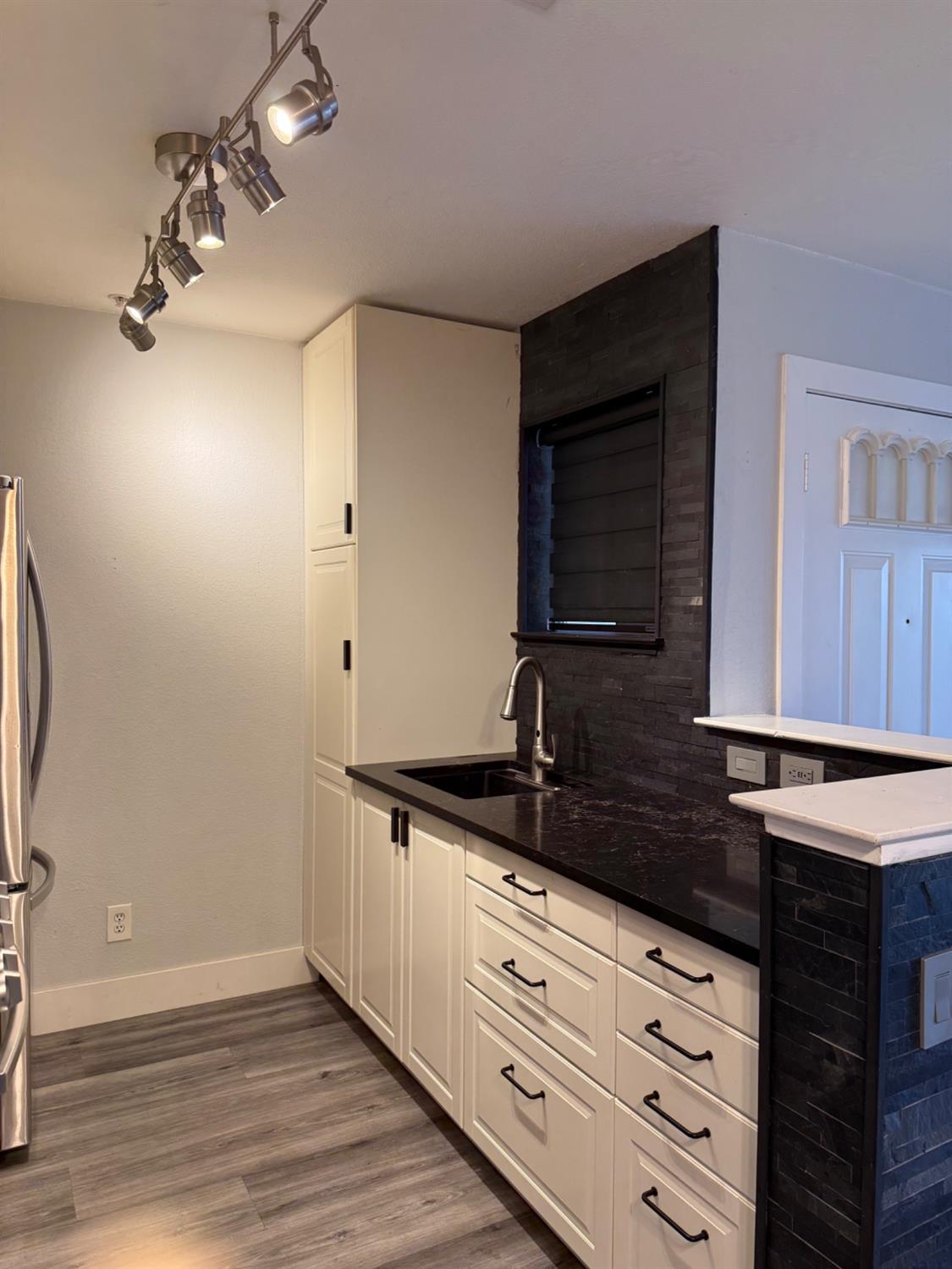 8020 Walerga Road, Unit 1093 Antelope, CA 95843 - Photo 7 of 13 a kitchen with granite countertop white cabinets and black appliances