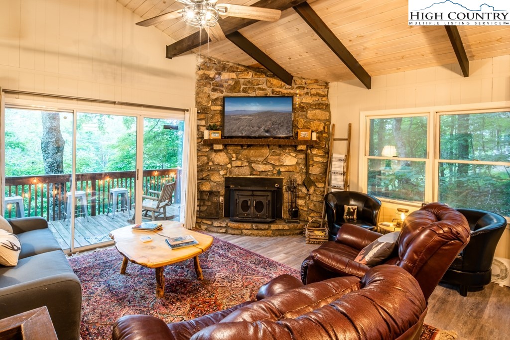 228 Pine Ridge Road Beech Mountain, NC 28604 - Photo 11 of 33 a living room with furniture a flat screen tv and a fireplace