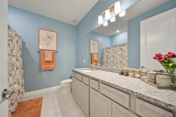 a bathroom with a granite countertop sink a large mirror and shower