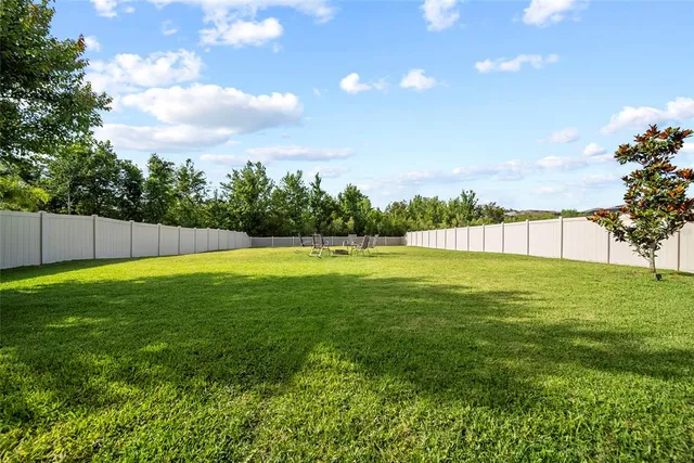 a view of yard with swimming pool and green space