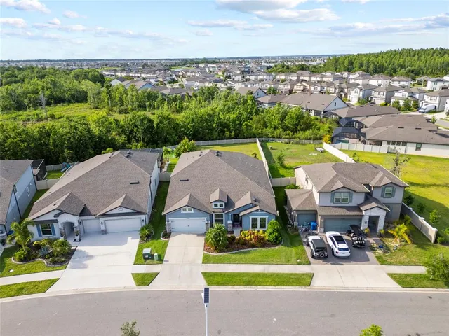 an aerial view of a house with a garden and lake view